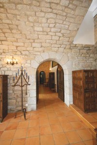 L’architecture intérieure fait preuve d’élégance. Murs en granit et portes voûtées. A gauche,   chandelier en fer forgé XIXème.
